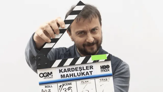 Ali Atay, Kardeşler Mahlukat setinde yapımın adının yazılı olduğu klaketi elinde tutarken görülüyor.