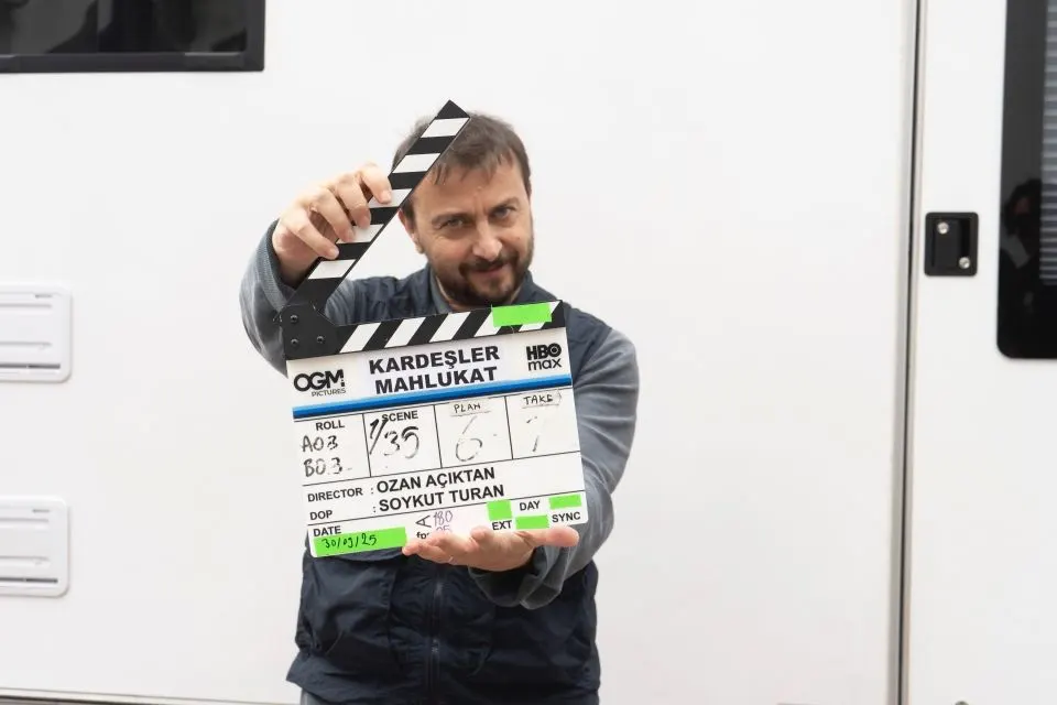 Ali Atay karavanın önünde dizinin klaketiyle poz veriyor.