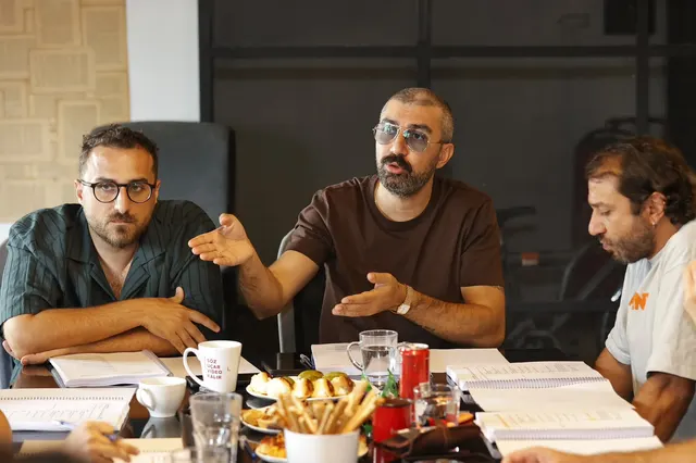 Nemlizade ekibinden üç kişi, okuma provası sırasında aynı masada oturarak birbirleriyle konuşuyor.