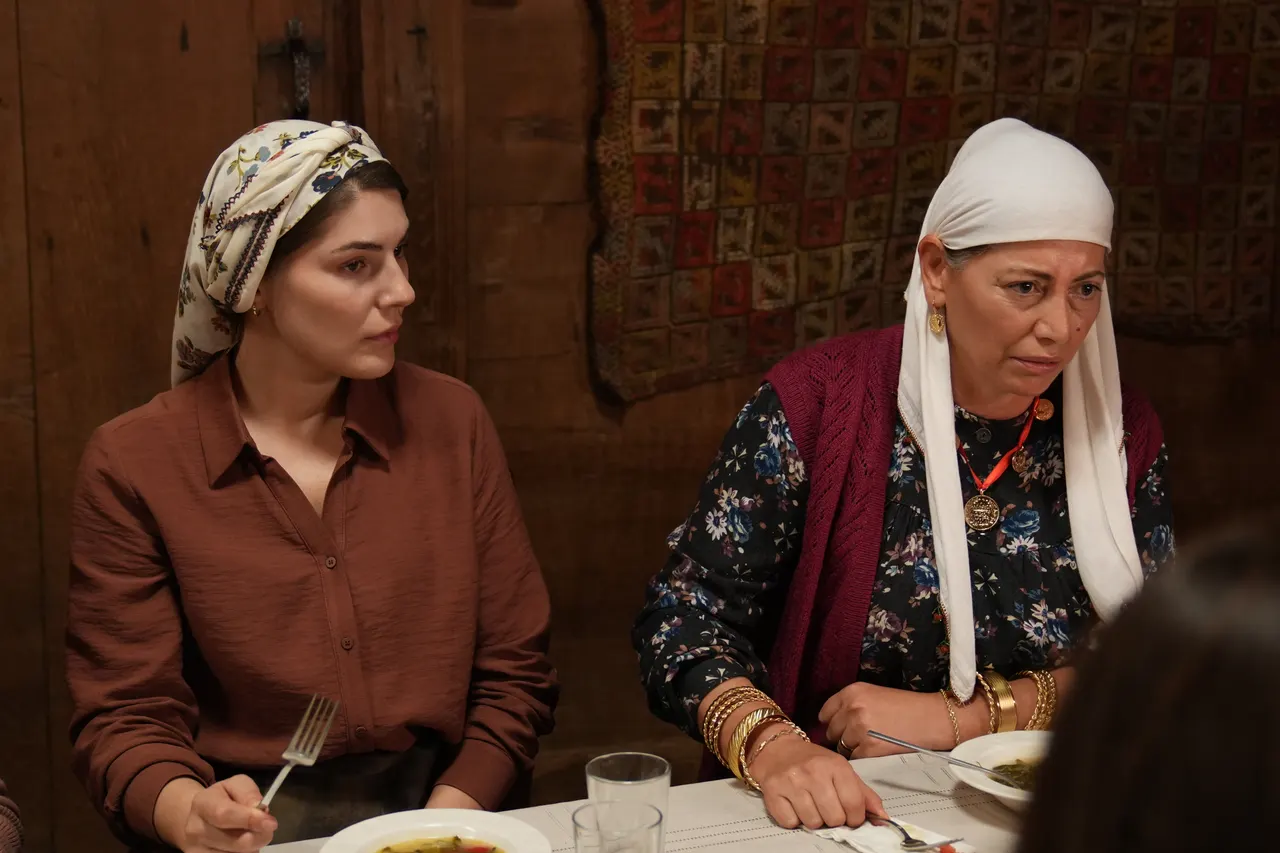 Başörtülü iki kadın masada oturuyor.